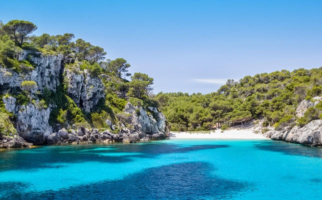 Les aigües blaves i la natura salvatge de la cala Macarelleta Les aigües blaves i la natura salvatge de la cala Macarelleta