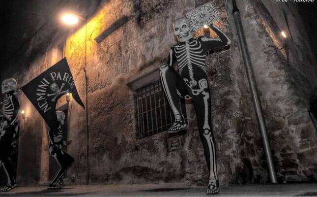 Un dels esquelets de la Dansa de la Mort de Verges, portant el rellotge sense busques