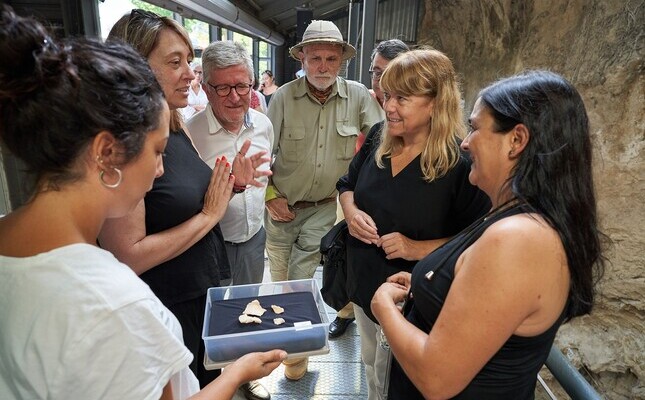 Arqueòlegs i autoritats contemplen els fragments de crani neardental de l'Abric Romaní