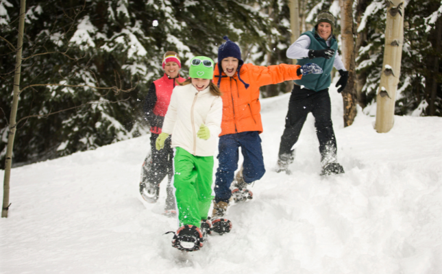 Família fent una ruta amb raquetes de neu Família fent una ruta amb raquetes de neu