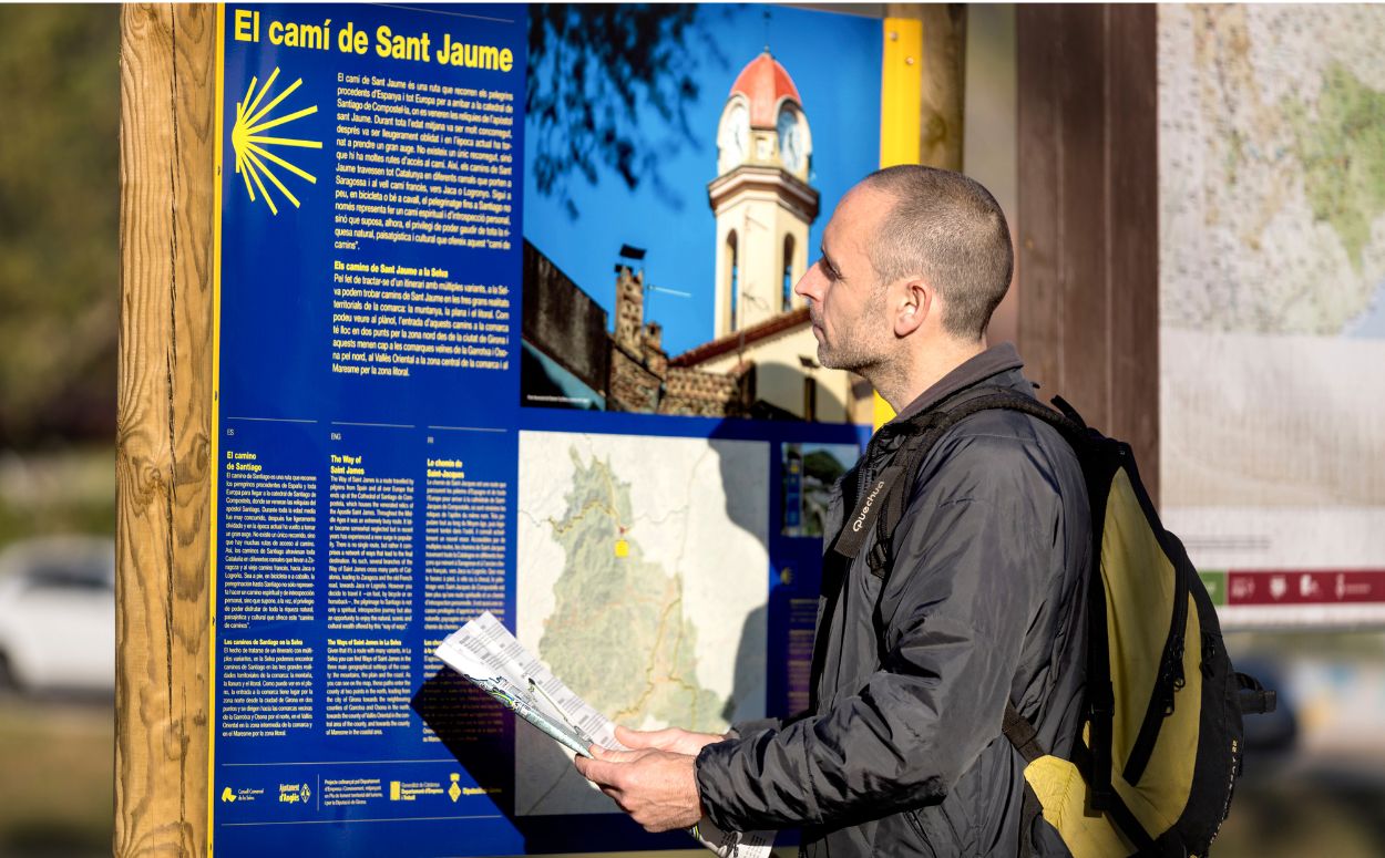 Un noi consulta el plafó informatiu del Camí de Sant Jaume