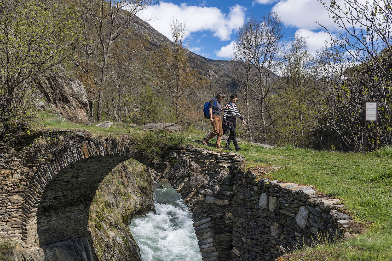 La Carme Ruscalleda i la Cristina Simó, la guia, passen sobre el pont de pedra d’Àrreu. És del segle XII, amb un sol arc de mig punt, i travessa la Noguera Pallaresa
