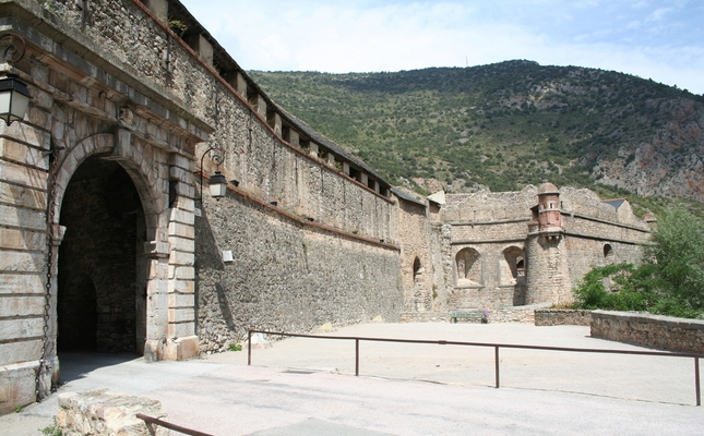 Vilafranca de Conflent és una població aturada en el temps. Les muralles que la cerquen completament, Patrimoni de la Humanitat, l’han protegida, conservant així tot l’encant medieval. I com una talaia, el fort vigila des de les altures Vilafranca de Conflent és una població aturada en el temps. Les muralles que la cerquen completament, Patrimoni de la Humanitat, l’han protegida, conservant així tot l’encant medieval. I com una talaia, el fort vigila des de les altures