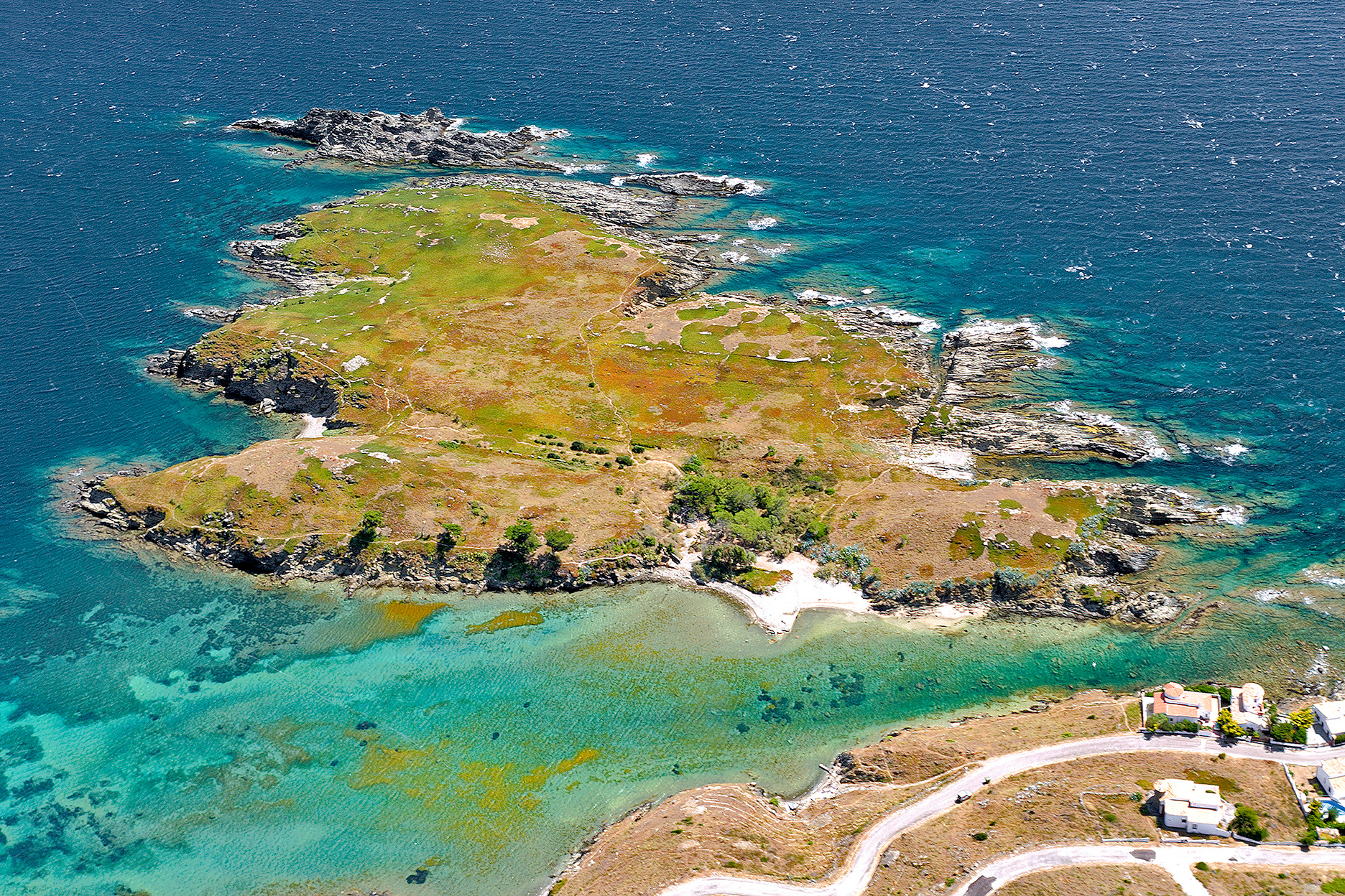 Des de l'aire, l'illa de Portlligat emergeix com una petita joia enmig del blau del mar