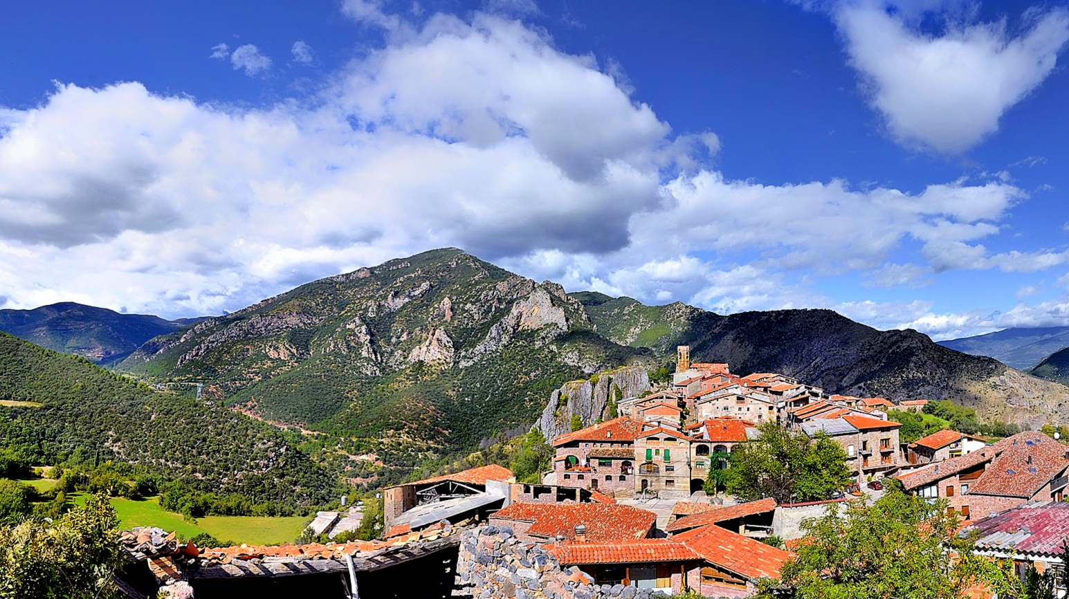 Les cases i l’església de Peramea, envoltades de muntanyes Les cases i l’església de Peramea, envoltades de muntanyes