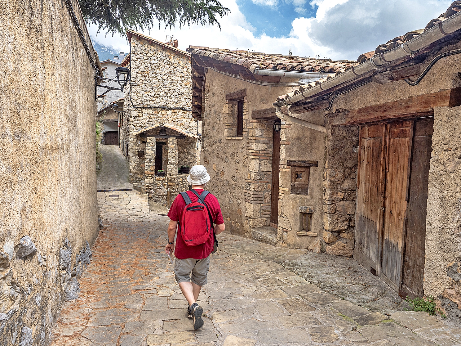  Un turista passeja per un dels carrers del barri de la Guàrdia de Gósol
