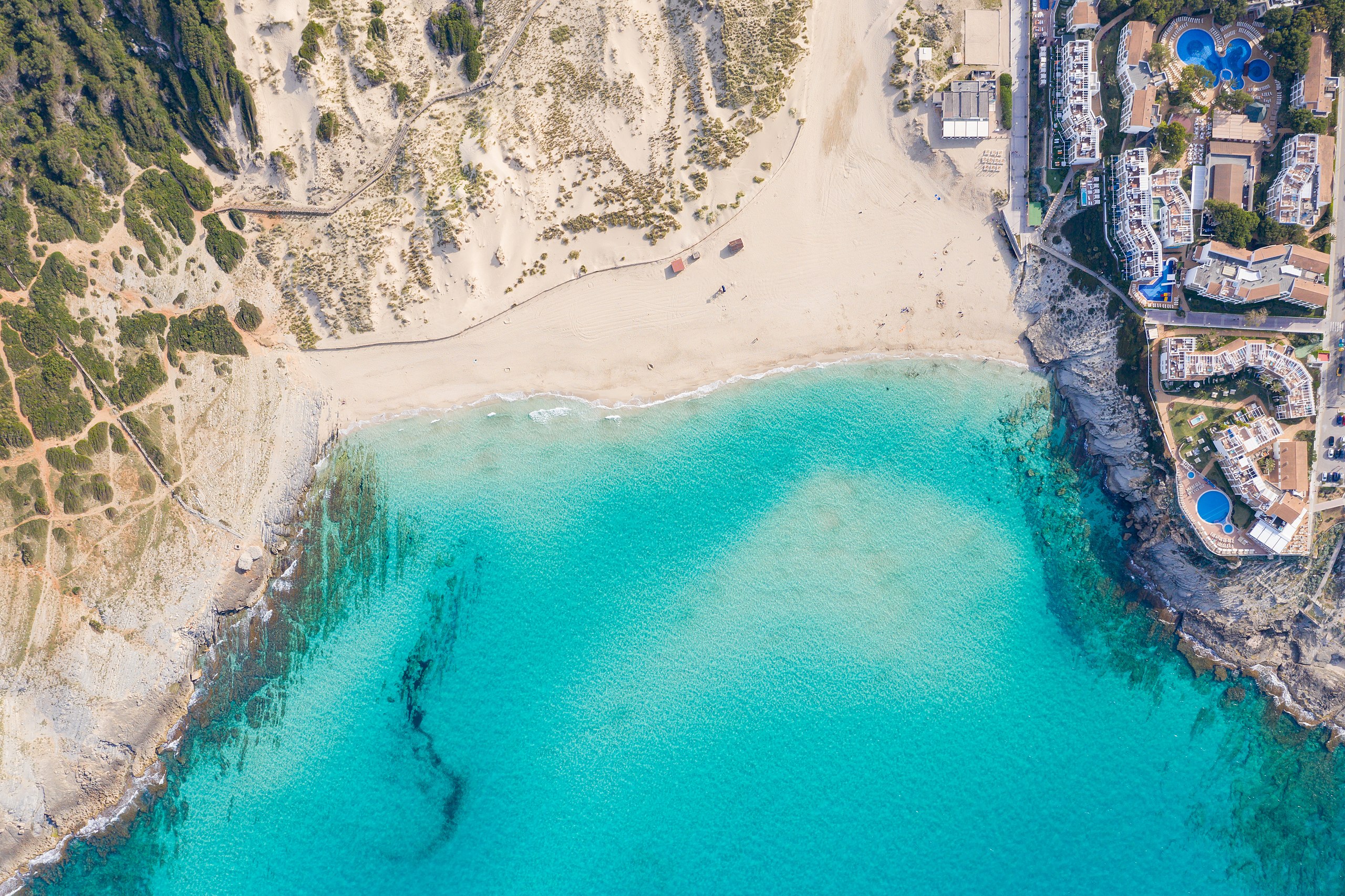 Des de l'aire, cala Mesquida desplega el seu gran sorral entre dunes, mar obert i natura mallorquina