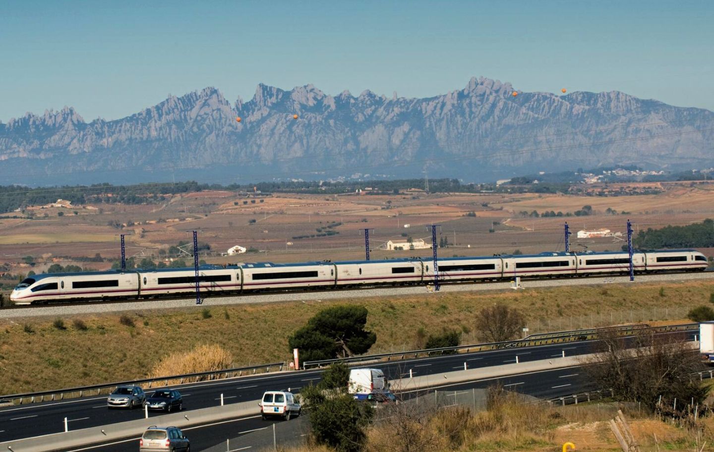 Tren d’alta velocitat al seu pas per Sant Sadurní d’Anoia, amb la muntanya de Montserrat al fons