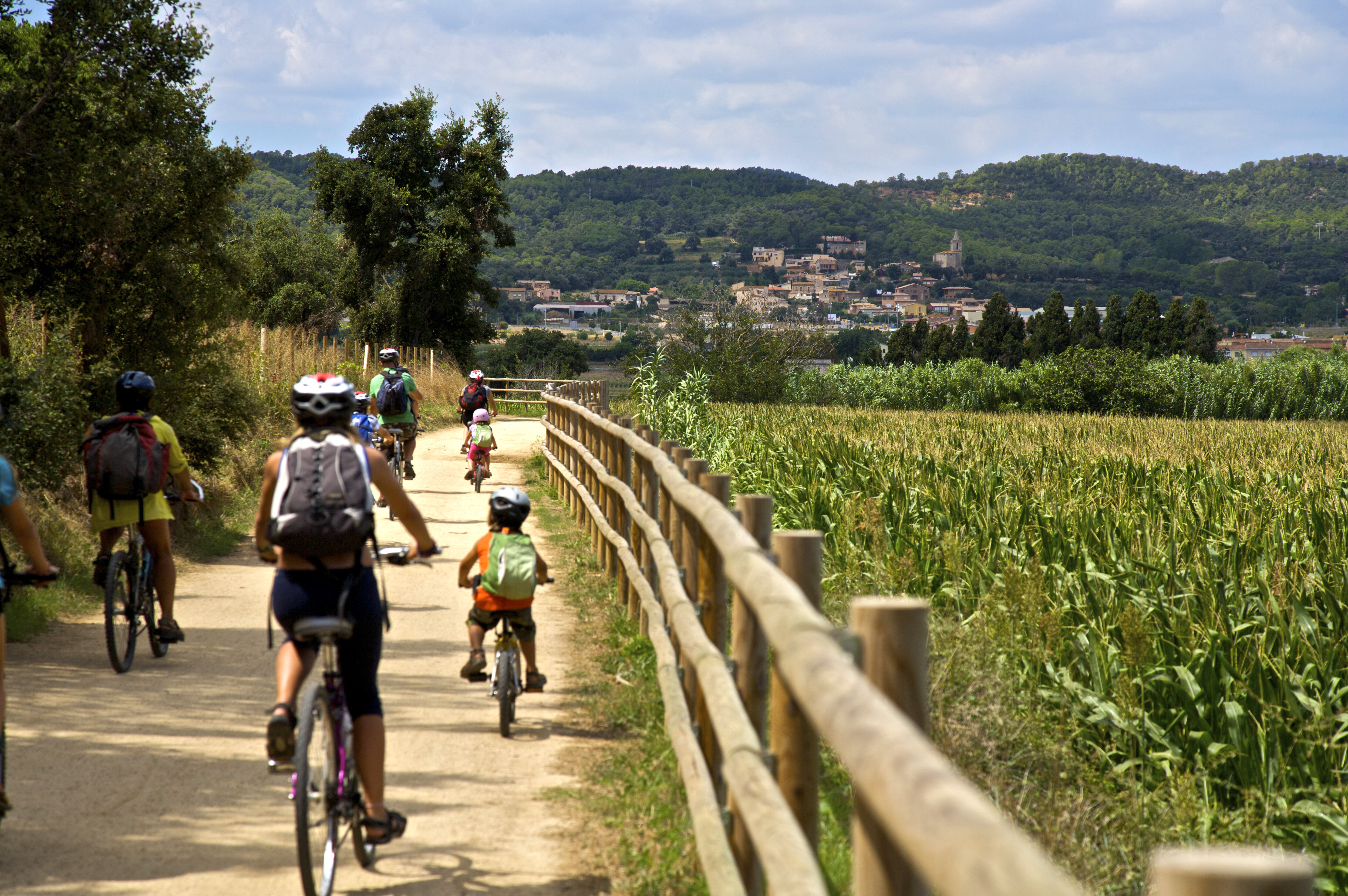 Uns ciclistes pedalen per la Ruta del Tren Petit en direcció a Mont-ras.