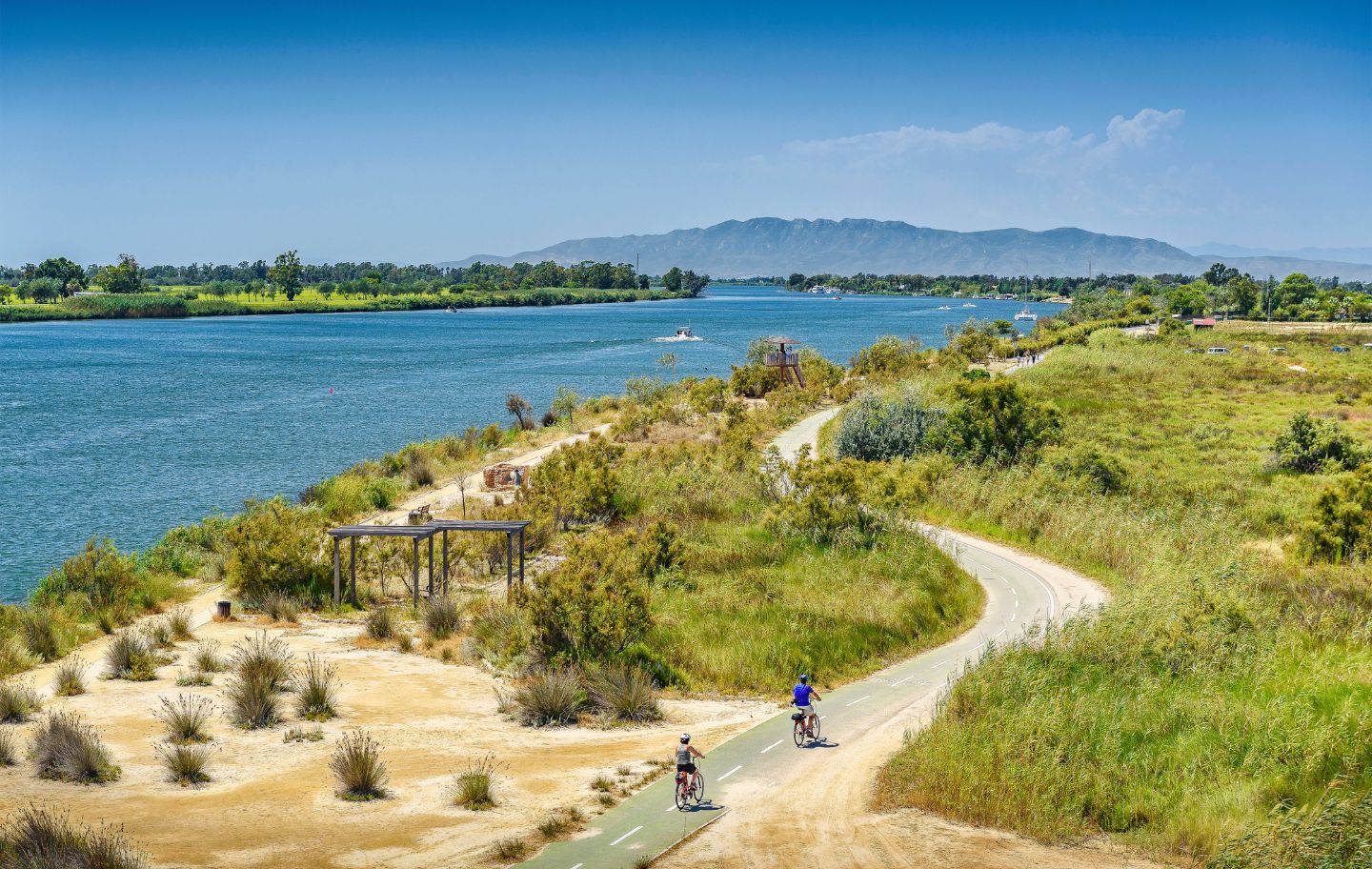 Dos cicloturistes pedalen Ebre amunt al costat del riu.