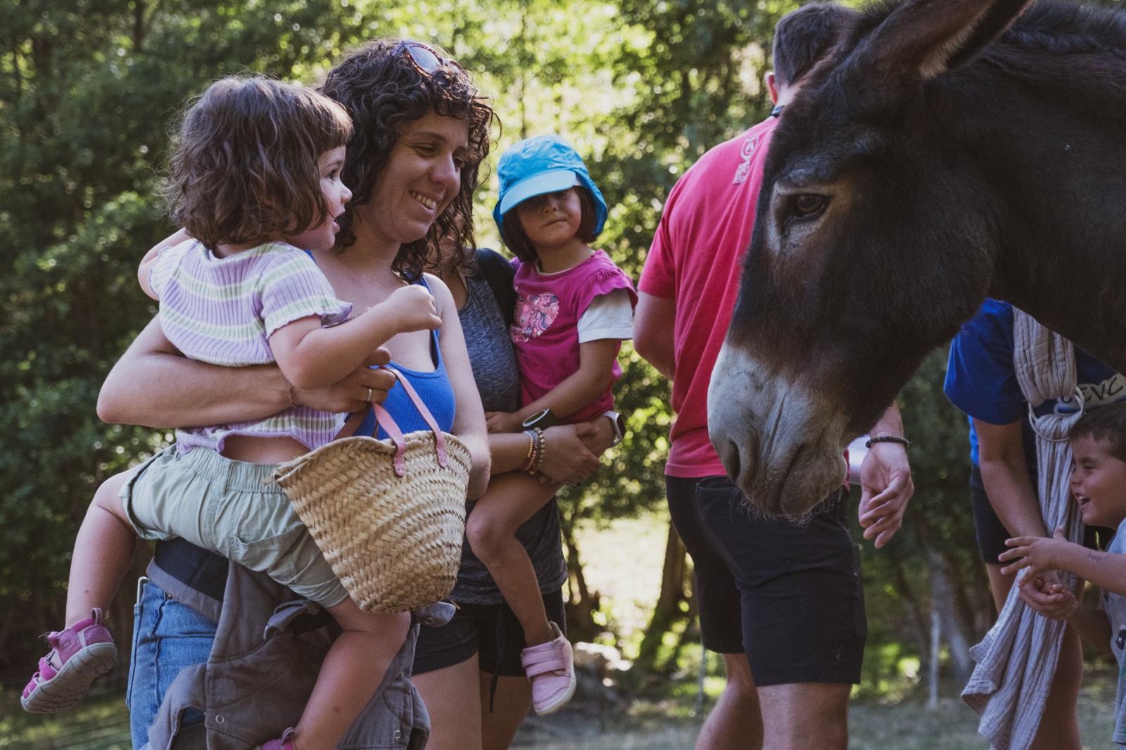 Mares i nens en una activitat amb rucs i cavalls al Cerdanya Ecoresort