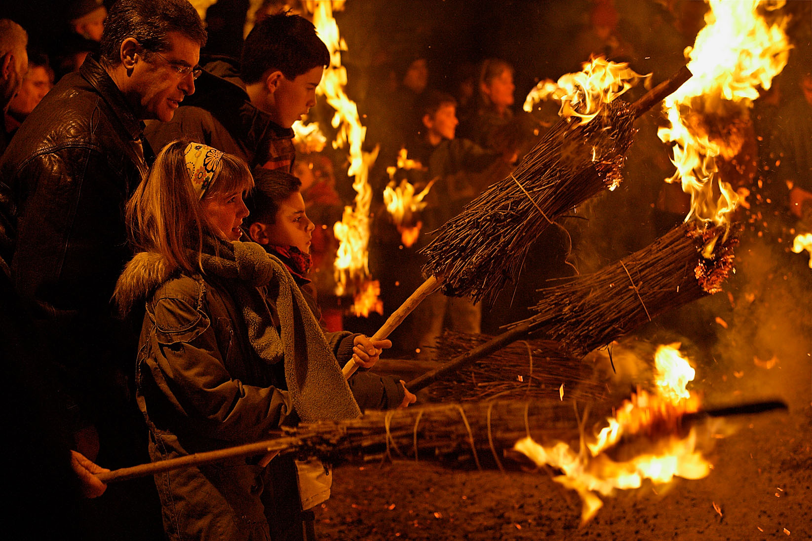 Una nena sosté una falla a la plaça de Sant Julià de Cerdanyola la nit de la Fia-faia