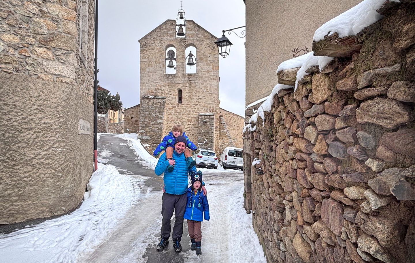 En Roc, la Tanit i el seu pare passegen per Dorres, amb l'església romànica de Santa Joan al darrera