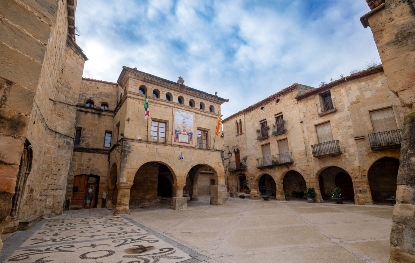La façana de l'Ajuntament d'Horta de Sant Joan corona altiu la plaça de l'església