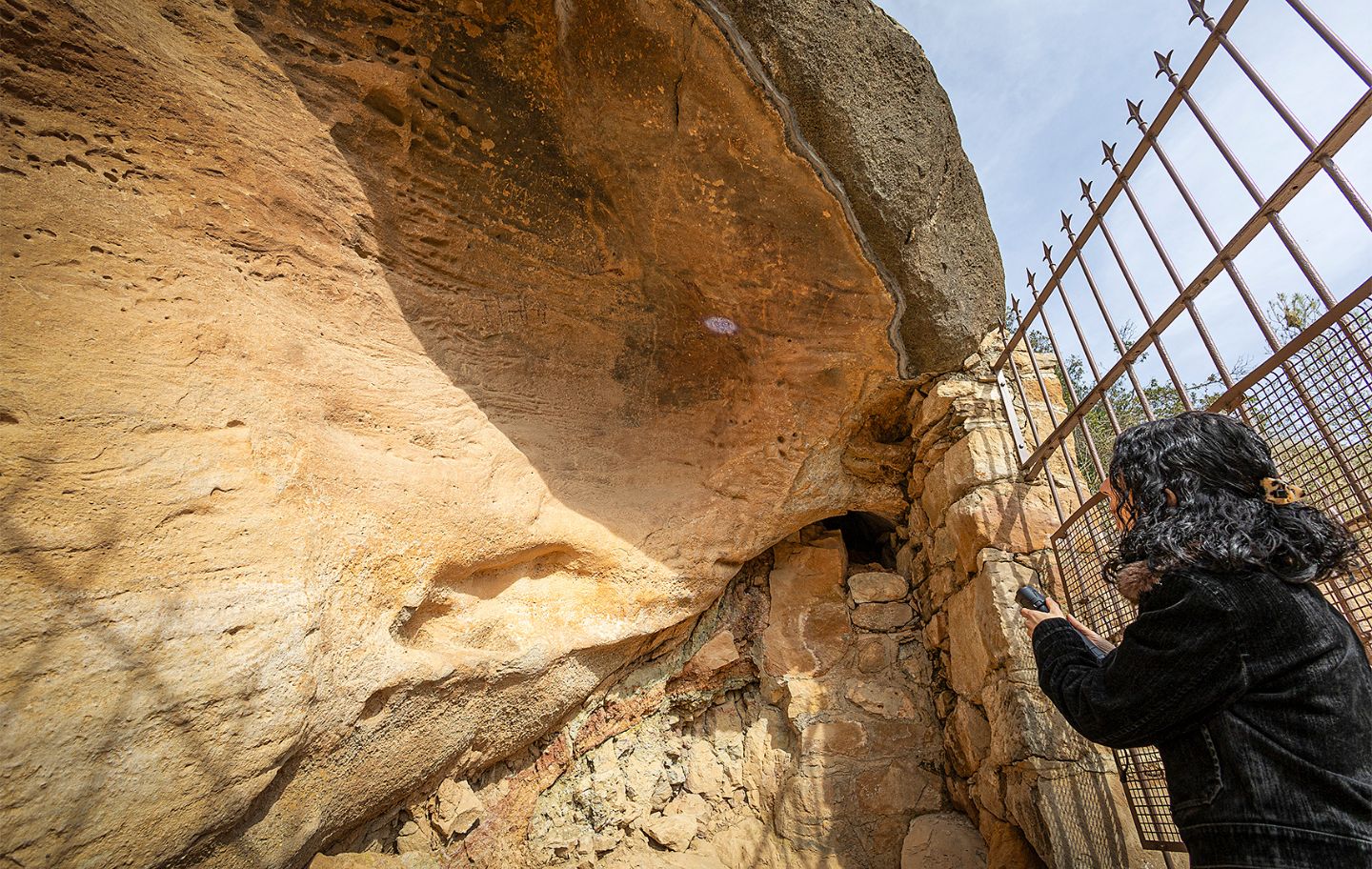 La guia mostra els detalls de les pintures rupestres de la Roca dels Moros