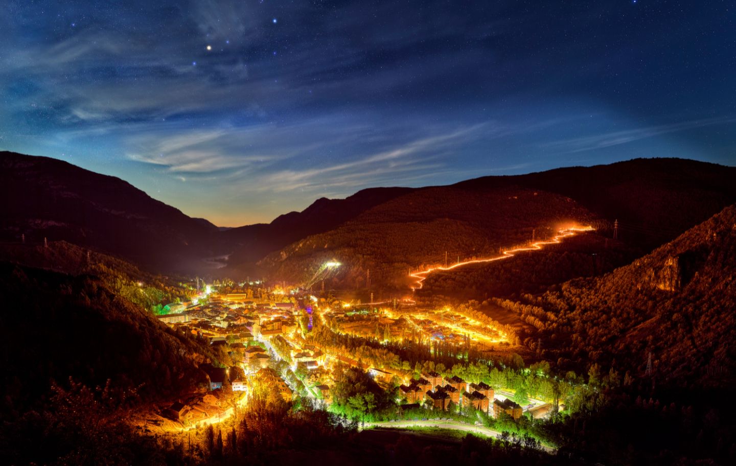 Als Pirineus, la baixada de falles encén la nit de Sant Joan amb una serp de foc que uneix muntanya, poble i tradició