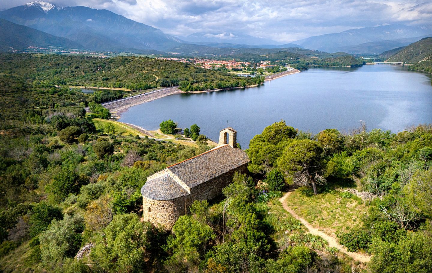 L'església de Sant Pere de Bell-lloc corona el turó del mateix nom, des d'on hi ha una vista privilegiada del pantà de Vinçà i del Canigó