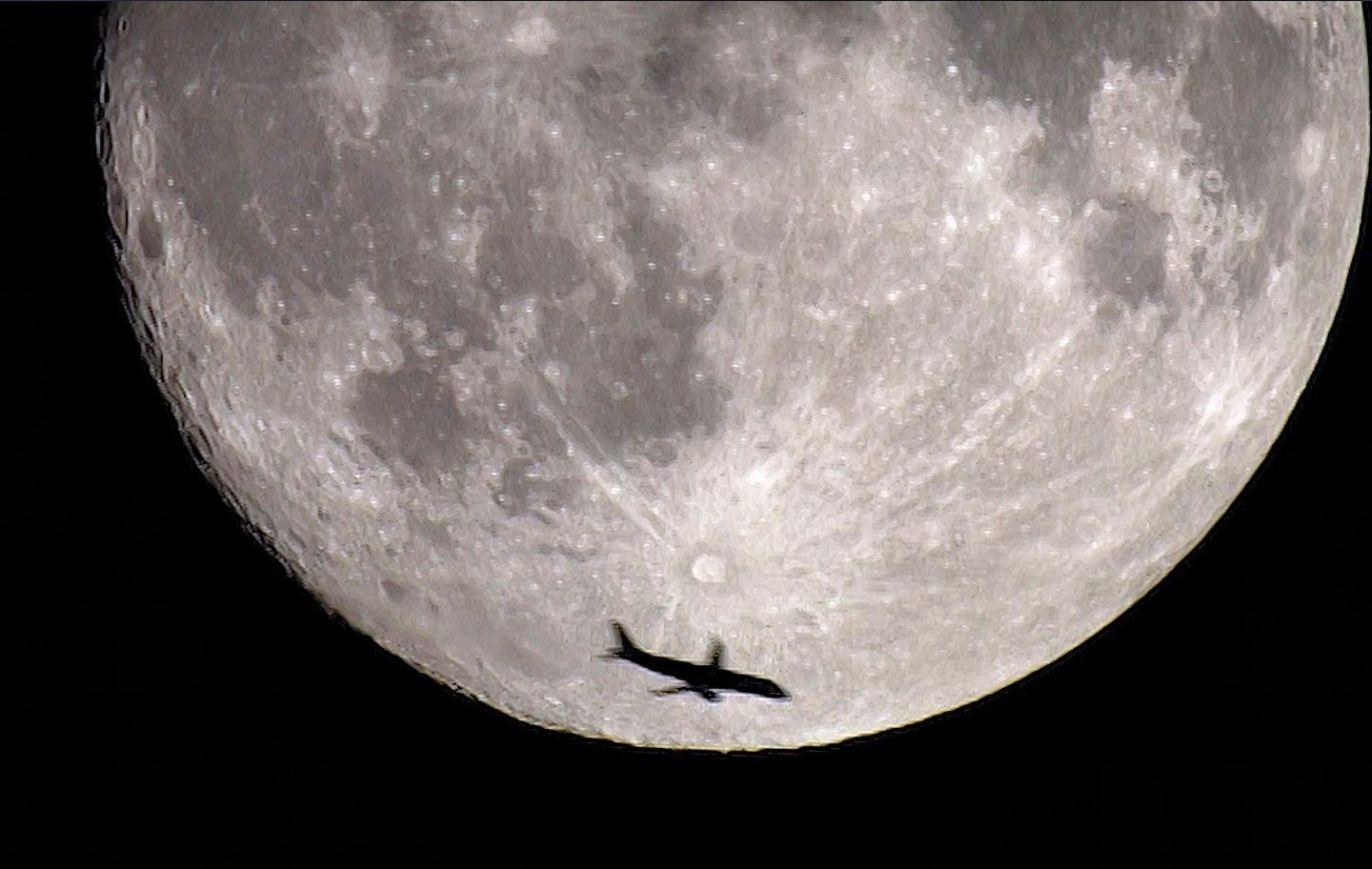 En aquesta imatge feta des de Vic, un avió passa sota el cràter Tycho de la Lluna