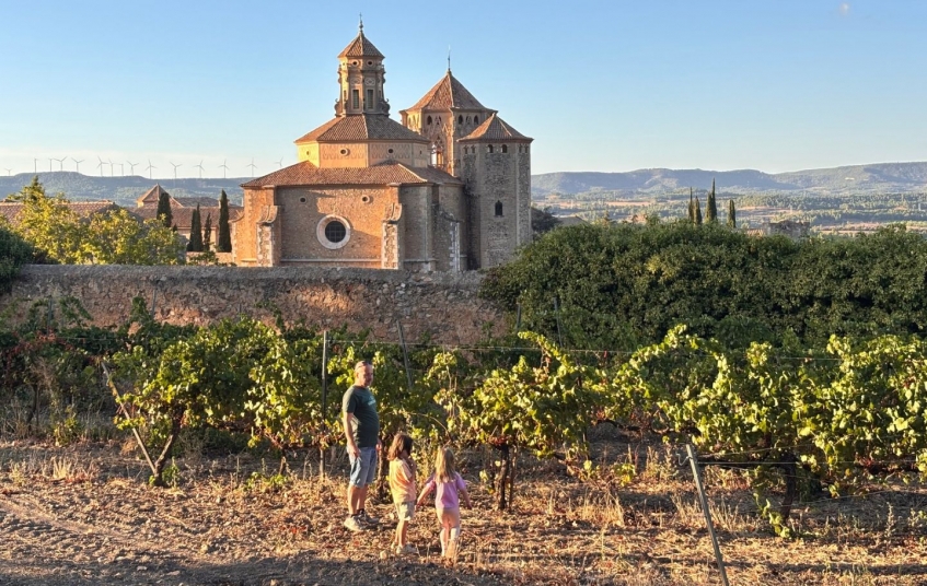 La família passeja per les vinyes del costat del monestir de Poblet, al fons La família passeja per les vinyes del costat del monestir de Poblet, al fons