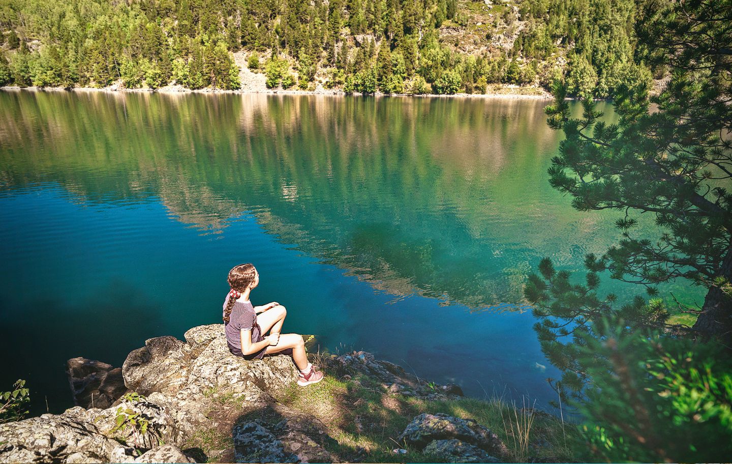 L’Alma, la filla de l'Álvaro Sanz, es queda observant la bellesa de l’estany de Sant Maurici, envoltat  de boscos de pi negre